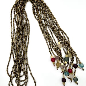 May include: A long gold beaded necklace with multiple strands and colorful glass beads at the end.