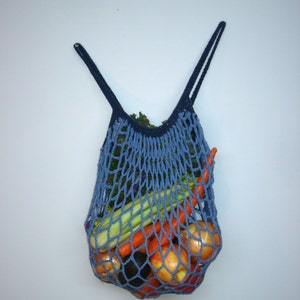 May include: A blue crocheted mesh bag filled with produce, including carrots, onions, apples, and celery.