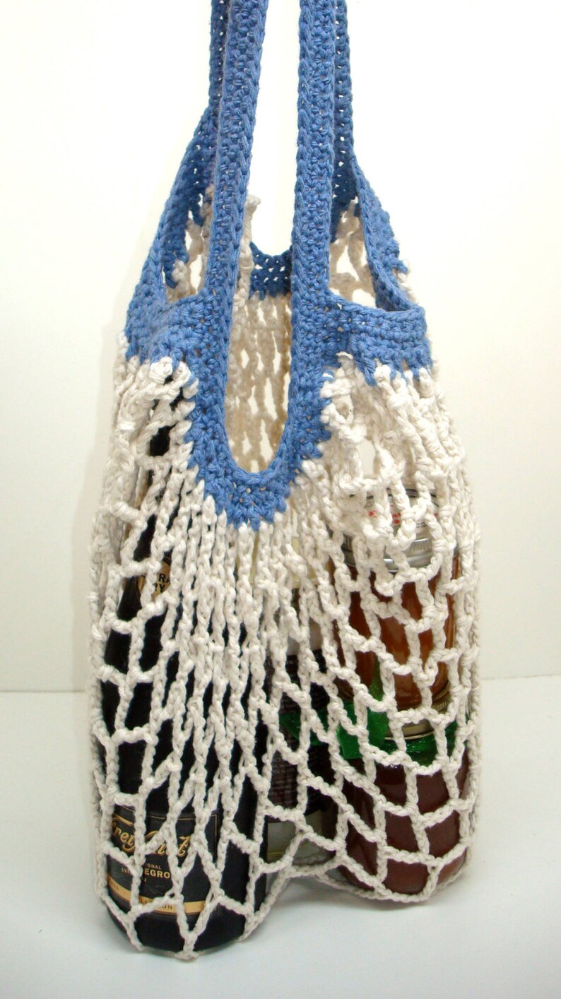 May include: A white crocheted string bag with blue handles. The bag is filled with a glass bottle and jars.