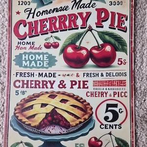 Peut inclure: Une plaque en métal rectangulaire présentant une publicité de style vintage pour une tarte aux cerises. Le design inclut des illustrations de cerises rouge vif, une tarte à croûte quadrillée sur un pied bleu et du texte comme "CHERRRY PIE".