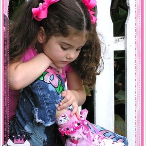 May include: A young girl with pink bows in her hair sits on a white picket fence wearing a pink and white high-top sneaker with the word "Princess" on it.