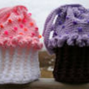 Peut inclure: Deux contenants en forme de cupcake crochet&eacute;s, l'un rose et blanc avec des pois roses et l'autre violet et noir avec des pois violets.