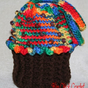 Peut inclure: Un chapeau en crochet en forme de cupcake avec un motif ray&eacute; color&eacute; et des perles brunes. Le chapeau est fait d'un fil brun doux et a une base en crochet brun.
