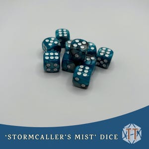 May include: A cluster of teal and white dice with rounded edges. Each die features white pips. The dice are labelled "Stormcaller's Mist" and are suitable for tabletop games.
