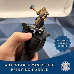 Peut inclure: Poignée de peinture miniature noire réglable avec une prise texturée, tenant une figurine. La figurine est vêtue d'une armure bleue et dorée et tient un marteau. L'image comprend le texte "MULTIPLE COLOUR OPTIONS" et "ADJUSTABLE MINIATURE PAINTING HANDLE".
