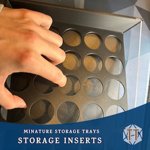 May include: Black plastic storage tray with circular cutouts for miniature storage. The tray is labelled "Miniature Storage Trays Storage Inserts".