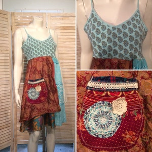 Puede incluir: Un vestido de patchwork azul y marrón con un detalle de bolsillo de ganchillo. El vestido tiene una falda de capas y un corpiño sin mangas.