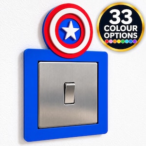 May include: A blue square light switch cover plate featuring a circular red, white, and blue shield emblem with a central white star. A metallic silver light switch is centred within the plate. A circular badge displays 33 COLOUR OPTIONS.