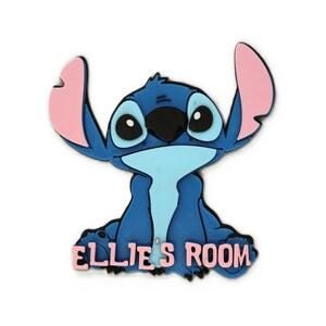 Op de afbeelding: Een blauw en lichtblauw wandbord in de vorm van een personage met grote oren met roze binnenkanten, zwarte ogen en een zwarte neus. Het personage zit in een zittende houding met de tekst "ELLIE'S ROOM" in roze hoofdletters onderaan.