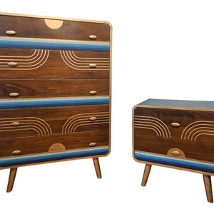 Puede incluir: Un conjunto de dos cómodas de madera con un diseño moderno de mediados de siglo. Las cómodas tienen un acabado en madera oscura con detalles azules y dorados. La cómoda más grande tiene cuatro cajones y la más pequeña tiene dos cajones.