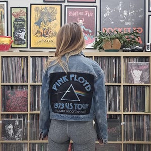May include: A denim jacket with a black patch featuring the Pink Floyd logo and the text "1973 US Tour The Dark Side of the Moon".