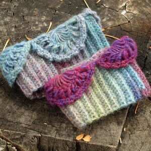 May include: Two crocheted wrist warmers with a striped pattern and a decorative crocheted trim. One warmer is blue and purple, the other is pink and green.