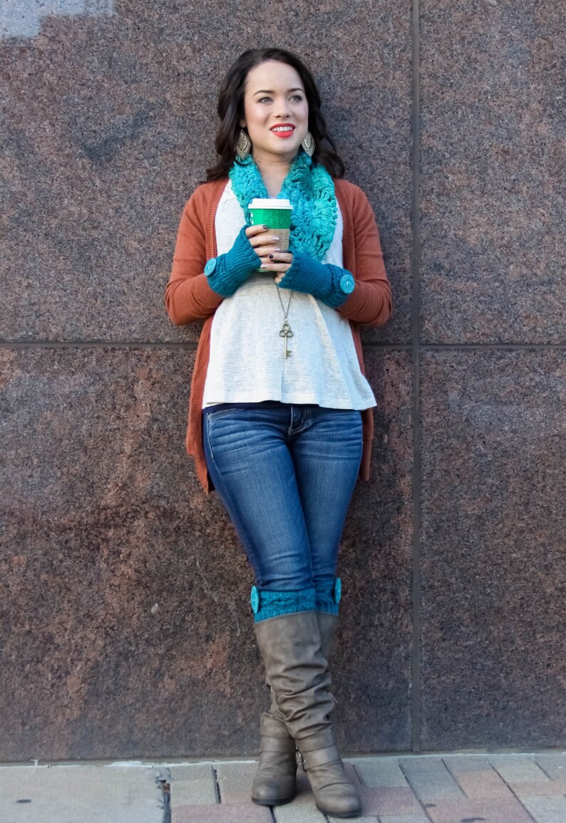 Puede incluir: Una mujer con un c&aacute;rdigan marr&oacute;n, una camisa blanca, pantalones vaqueros azules y botas marrones con polainas de punto turquesa. Est&aacute; sosteniendo una taza de caf&eacute; para llevar y mirando hacia arriba.