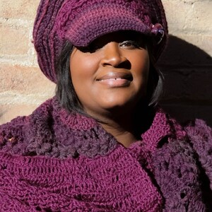 Puede incluir: Conjunto de gorro y bufanda de ganchillo en tonos morados. El gorro tiene visera y un bot&oacute;n decorativo. La bufanda es del mismo color y patr&oacute;n. El conjunto est&aacute; hecho de un hilo suave y texturizado.