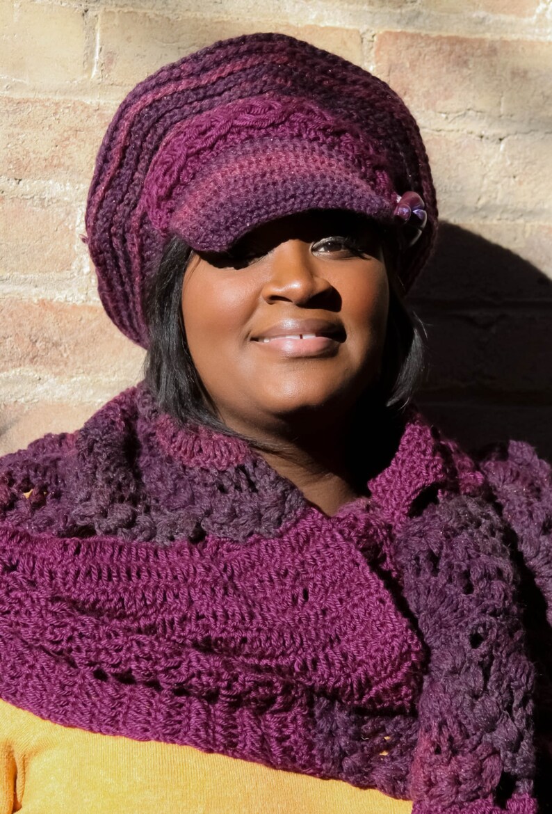 Puede incluir: Conjunto de gorro y bufanda de ganchillo en tonos morados. El gorro tiene visera y un bot&oacute;n decorativo. La bufanda es del mismo color y patr&oacute;n. El conjunto est&aacute; hecho de un hilo suave y texturizado.