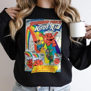 以下が含まれることがあります： ヴィンテージのKool-Aidグラフィックが特徴の黒いスウェットシャツ。グラフィックには、「INTRODUCING RAINBOW PUNCH FROM Kool-Aid」というテキスト、虹、漫画のキャラクター、Kool-Aidのパッケージが含まれています。「IT'S A BLEND OF SIX LIGHT FRUITY FLAVORS IN ONE REFRESHING PUNCH」というテキストも含まれています。