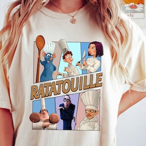 May include: Beige t-shirt featuring a colorful graphic from the animated film "Ratatouille." The design includes cartoon characters and the film's title in a bold font. The characters are depicted in a comic book style.