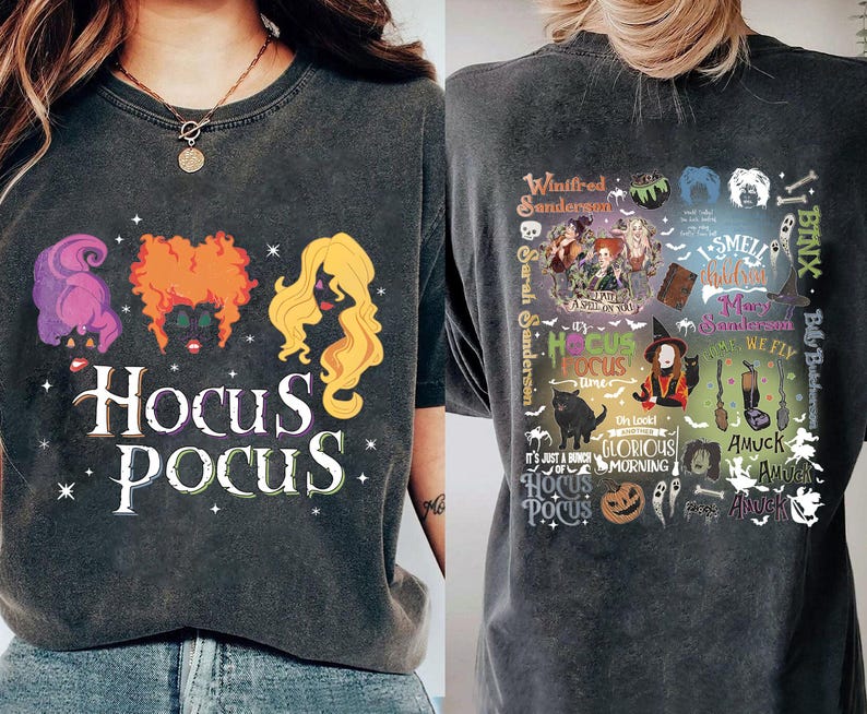 May include: Dark gray t-shirt featuring the text "Hocus Pocus" with illustrations of three witches' hair. The back of the shirt has a collage of images and text related to the movie, including "Winifred Sanderson" and "It's just a bunch of Hocus Pocus."