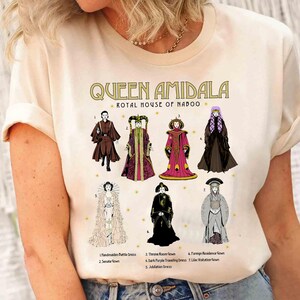 May include: A white t-shirt with a graphic print of Queen Amidala from Star Wars. The graphic shows Queen Amidala in different outfits with the text "Queen Amidala Royal House of Naboo".