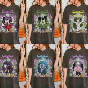 Pu&ograve; includere: Sei magliette grigio scuro con personaggi Disney a tema Halloween. Ogni maglietta presenta un personaggio diverso all'interno di una cornice decorativa con un fiocco, ragnatele e accenti floreali. I personaggi includono Minnie Mouse, Topolina, Topolino e altri.