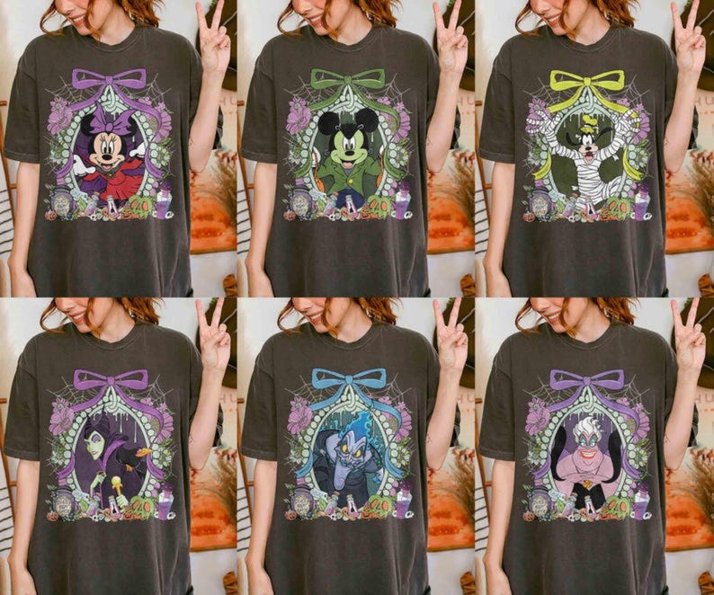 Pu&ograve; includere: Sei magliette grigio scuro con personaggi Disney a tema Halloween. Ogni maglietta presenta un personaggio diverso all'interno di una cornice decorativa con un fiocco, ragnatele e accenti floreali. I personaggi includono Minnie Mouse, Topolina, Topolino e altri.
