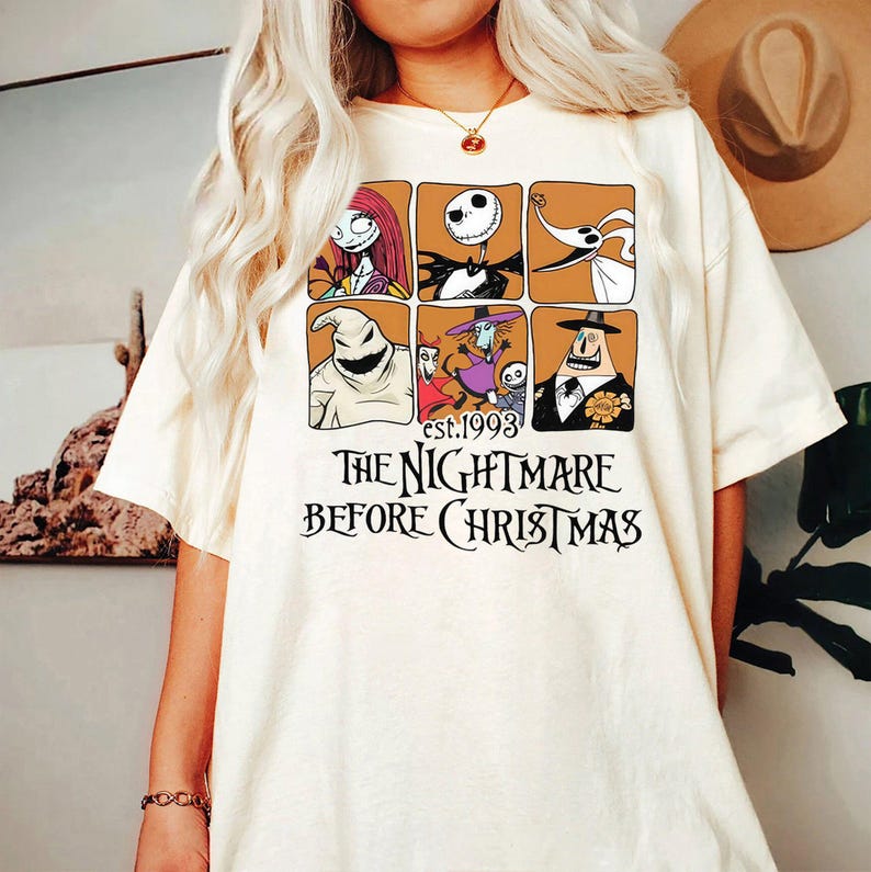 May include: Cream-colored t-shirt featuring a grid of six character illustrations from "The Nightmare Before Christmas" movie. The text "est.1993" and "THE NIGHTMARE BEFORE CHRISTMAS" are printed below the grid in black.