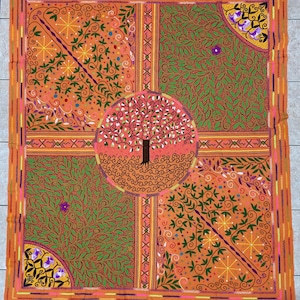 May include: An orange and green embroidered textile featuring a central tree design within a circle. The square textile is divided into four sections with floral and leaf patterns, and a decorative border.