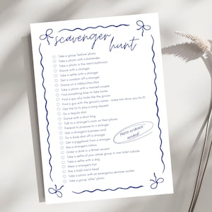 Op de afbeelding: Een afdrukbare speurtochtlijst op wit papier met blauwe hartjes en tekst. De lijst bevat taken zoals het maken van een foto met een barman, dansen met een vreemde en een piggyback krijgen van een vreemde. De tekst "Fotobewijs nodig!" staat in een cirkel rechtsonder.