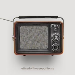 Op de afbeelding: Een vintage-stijl, bruin en zwarte televisie met een statisch scherm. De televisie heeft een zilveren knop en een zilveren handvat aan de bovenkant.