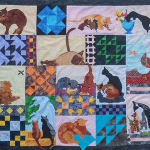 May include: A colorful quilt with a patchwork design featuring various cat illustrations. The quilt is made up of squares and triangles in different colors and patterns. The cats are depicted in various poses and sizes, some with kittens.