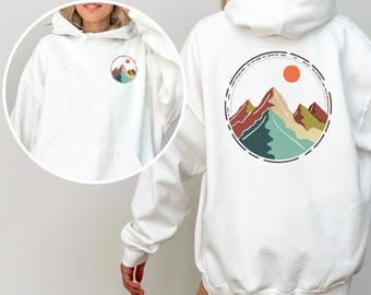 May include: White hoodie with a graphic of colorful mountains and a red sun in a circle on the back. The front of the hoodie has a smaller version of the graphic on the left chest.