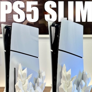 Peut inclure: Deux consoles PS5 Slim blanches, l'une avec lecteur de disque et l'autre numérique, sont présentées sur une surface en bois. Les deux consoles sont sur un support en cristal blanc.