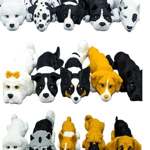 Può includere: Un set di 15 figurine di cani in miniatura di diverse razze e colori. Le figurine sono realizzate in un materiale morbido e gommoso e sono perfette per decorare una scrivania o uno scaffale.