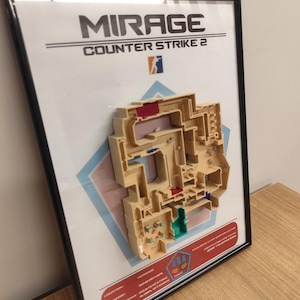 May include: A framed 3D map of the Mirage map from Counter-Strike 2. The map is made of beige plastic and features a variety of colors, including red, blue, and green. The frame is black and has a white background with the words "MIRAGE" and "COUNTER-STRIKE 2" printed in black.