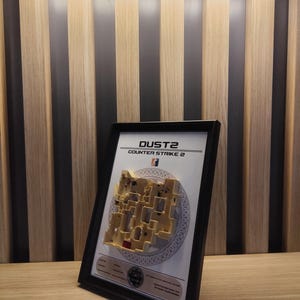 This photo captures the complete Dust2 miniature framed alongside the CS:GO logo and map information. The frame is designed to enhance the collectible’s presentation, making it ideal for wall or shelf display.
