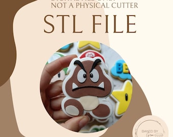 May include: A Goomba cookie from the Super Mario Bros. video game series, held in a hand. The cookie is brown, white, and tan with black accents. Other cookies are visible in the background. The text "DIGITAL FILE ONLY - NOT A PHYSICAL CUTTER" and "STL FILE" are at the top.