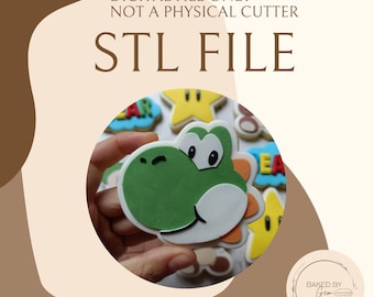 May include: Image of a green Yoshi cookie cutter design. The image includes the text "DIGITAL FILE ONLY - NOT A PHYSICAL CUTTER" and "STL FILE". Other cookies are visible in the background.