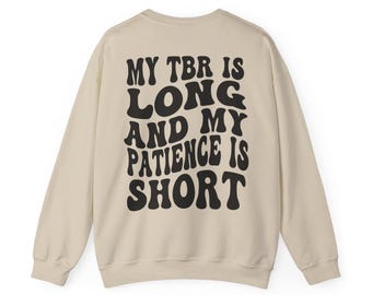 May include: Beige sweatshirt with black text that reads "My TBR is long and my patience is short" in a retro font.