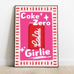 May include: A framed art print with a red Coke Zero can illustration on a pink background. The words "Coke Zero" and "Girlie" are written in white, stylized lettering. The print has a pink border with red dashes.