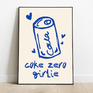 以下が含まれることがあります： クリーム色の背景に、ソーダ缶の青と白のイラスト。テキストは「coke zero girlie」。