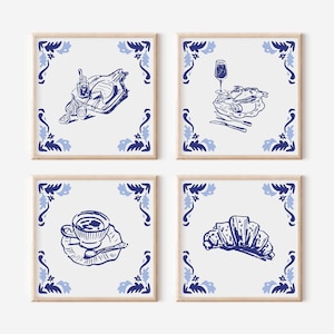 May include: Four framed prints featuring blue and white illustrations of food and drink. The prints depict a roasted chicken, a glass of wine with a plate of food, a cup of coffee, and a croissant. Each print has a decorative border.