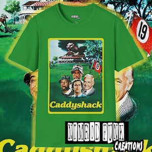 May include: Green t-shirt with a yellow and green image of the movie Caddyshack. The image features the main characters from the movie, including Bill Murray, Chevy Chase, and Rodney Dangerfield. The text "Caddyshack" is printed in yellow letters on the image. The text "Nimrod Funk Creations" is printed in black letters on the bottom of the shirt.