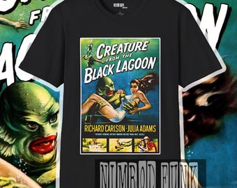 May include: Black t-shirt featuring a vintage movie poster design for "Creature from the Black Lagoon." The poster art includes the film's title, actors' names, and a graphic of the creature and a woman. The shirt also has the text "Nimrod Funk Creations."