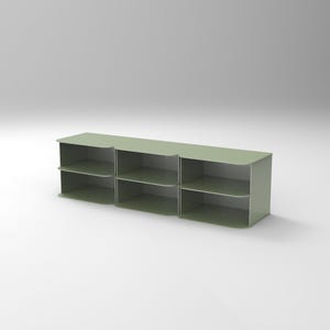 Puede incluir: Un estante modular verde salvia con tres secciones. Cada sección tiene dos estantes. La unidad está hecha de un material sólido y tiene un diseño minimalista, adecuado para diversas necesidades de almacenamiento. La unidad está sobre un fondo blanco liso.