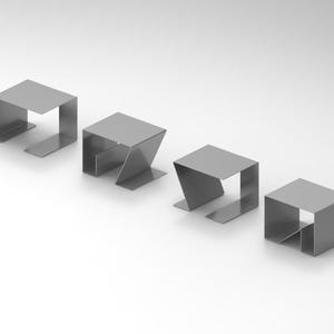 Puede incluir: Cuatro mesas auxiliares minimalistas de metal gris claro. Cada mesa tiene una parte superior cuadrada y una base única. Están dispuestas sobre una superficie blanca, con un diseño limpio y moderno.