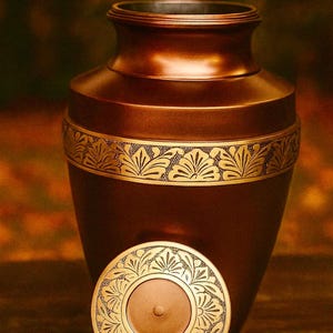 Urna de cremación de bronce con motivos de pan de oro y marrón natural. Elegante urna funeraria artesanal para cenizas de adultos.
