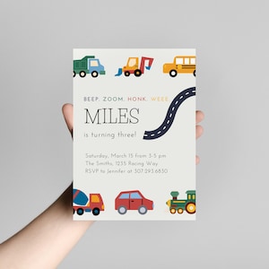 Puede incluir: Una invitación colorida para una fiesta de cumpleaños con un camino y varios vehículos, incluyendo un camión, una excavadora, un autobús, una mezcladora de cemento, un automóvil y un tren. El texto de la invitación dice "Beep. Zoom. Honk. Wee. Miles cumple tres años! Sábado 15 de marzo de 3 a 5 pm Los Smith, 1235 Racing Way RSVP a Jennifer al 307.293.6830"