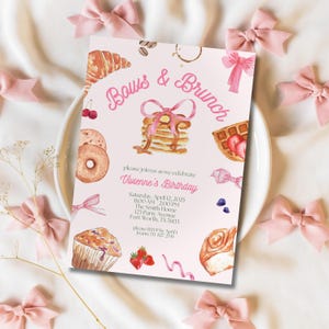 May include: A pink invitation card with the text "Bows & Brunch" and "Vivienne's Birthday". The card features watercolour illustrations of pastries, pancakes, and bows. Pink bows surround the invitation on a white surface.