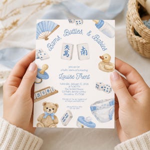 May include: A rectangular baby shower invitation card featuring blue watercolor illustrations of mahjong tiles, a teddy bear, a rubber duck, a baby bottle, a pacifier, and a diaper. The text reads: Bans, Bottles, & Babies, Louise Trent, January 17, 2026.