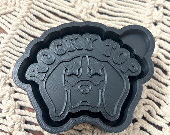 May include: Black silicone mold for baking cookies or other treats. The mold features a dog's head with the words "Rocky Top" around it.